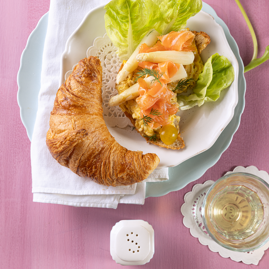 Roerei met dragon, asperge, zalm op een croissant