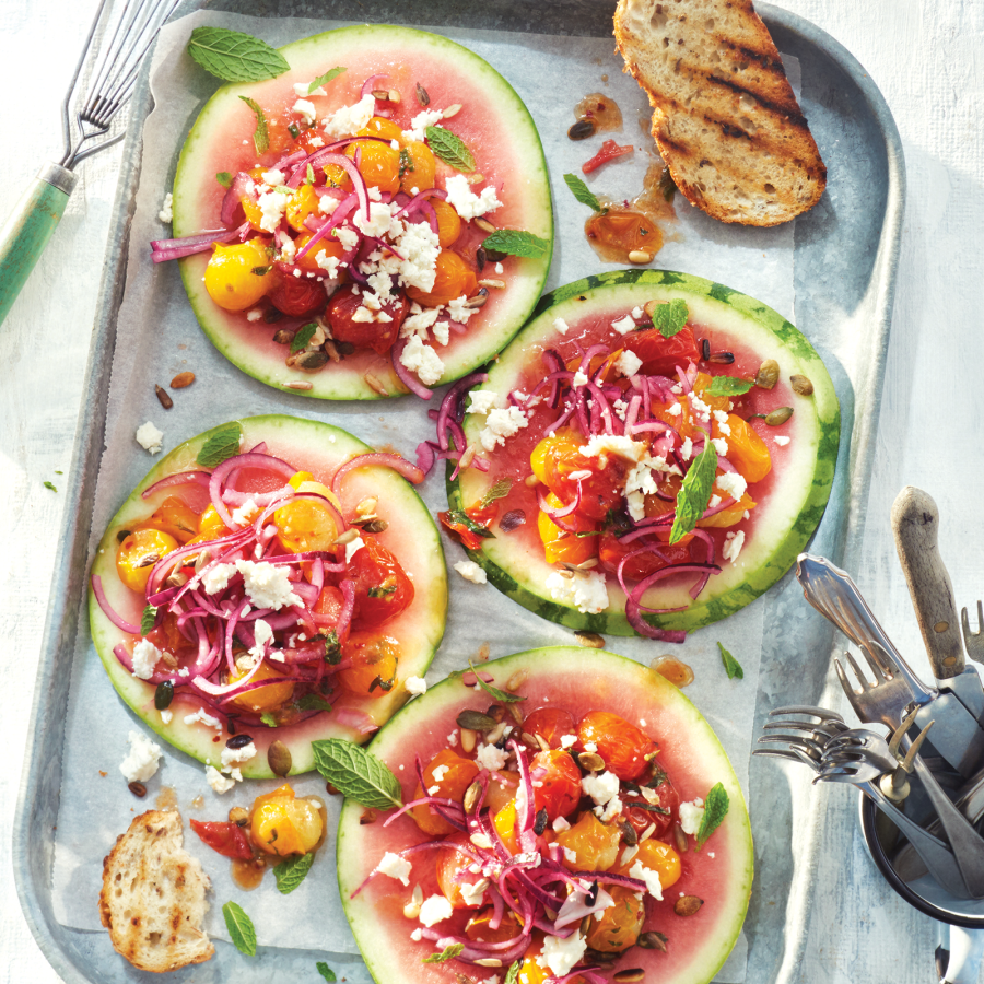 Watermeloen pizzaatjes met gemarineerde kerstomaatjes, munt en limoen en feta