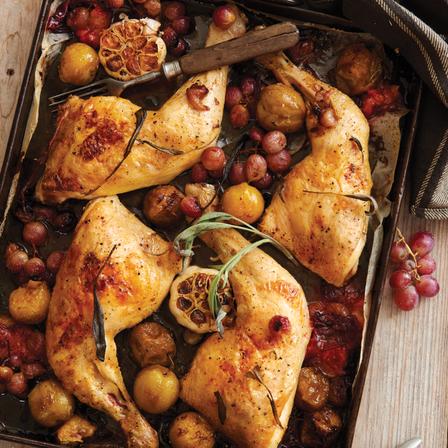 Geroosterde kippenbouten uit de oven met gepofte knoflook, salie, druiven en pruimen