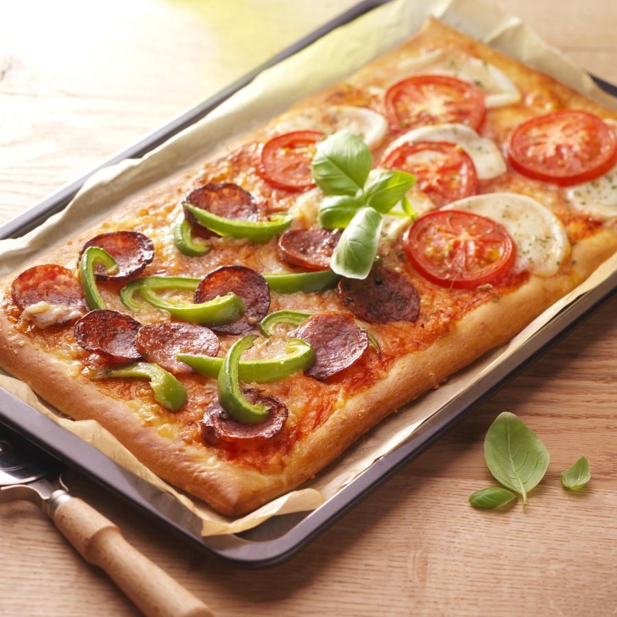 Zelfgemaakte pizza met salami en tomaat