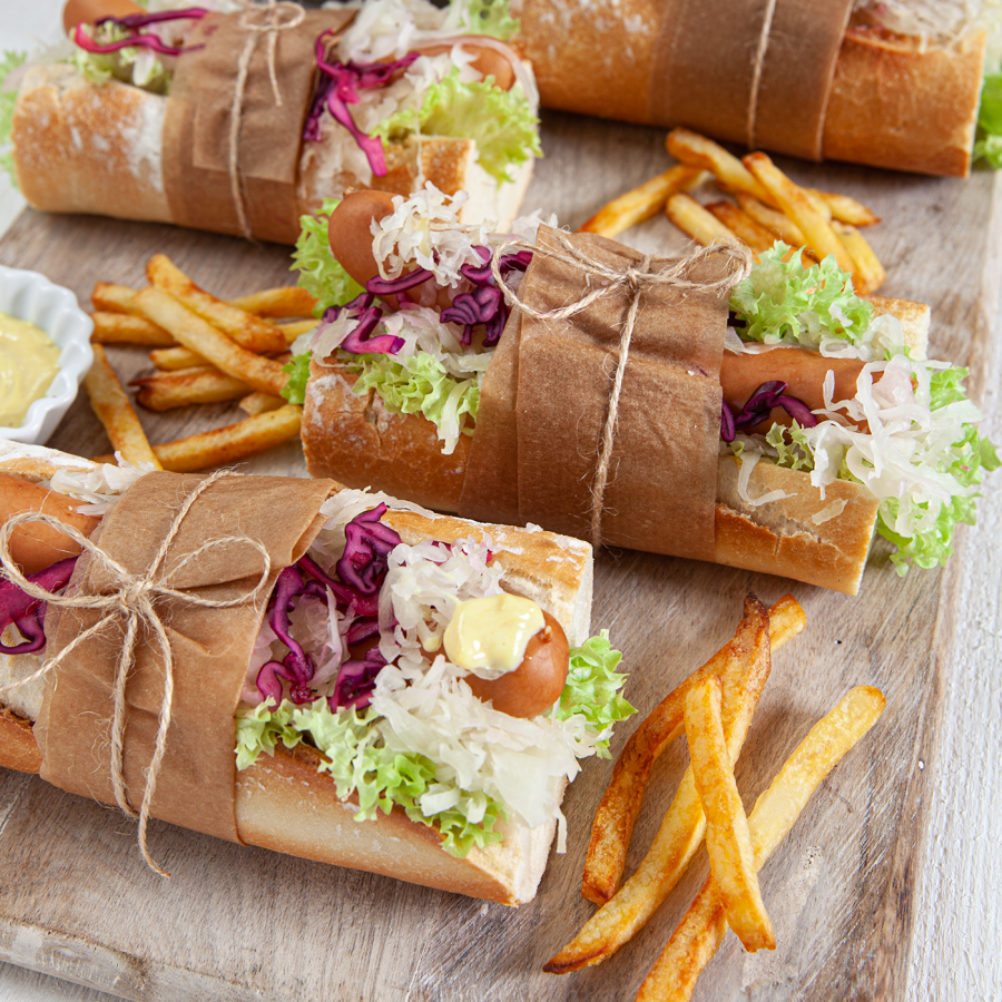 Winterse hotdog met krulsla, ui, zuurkool, rode kool en mosterdsaus