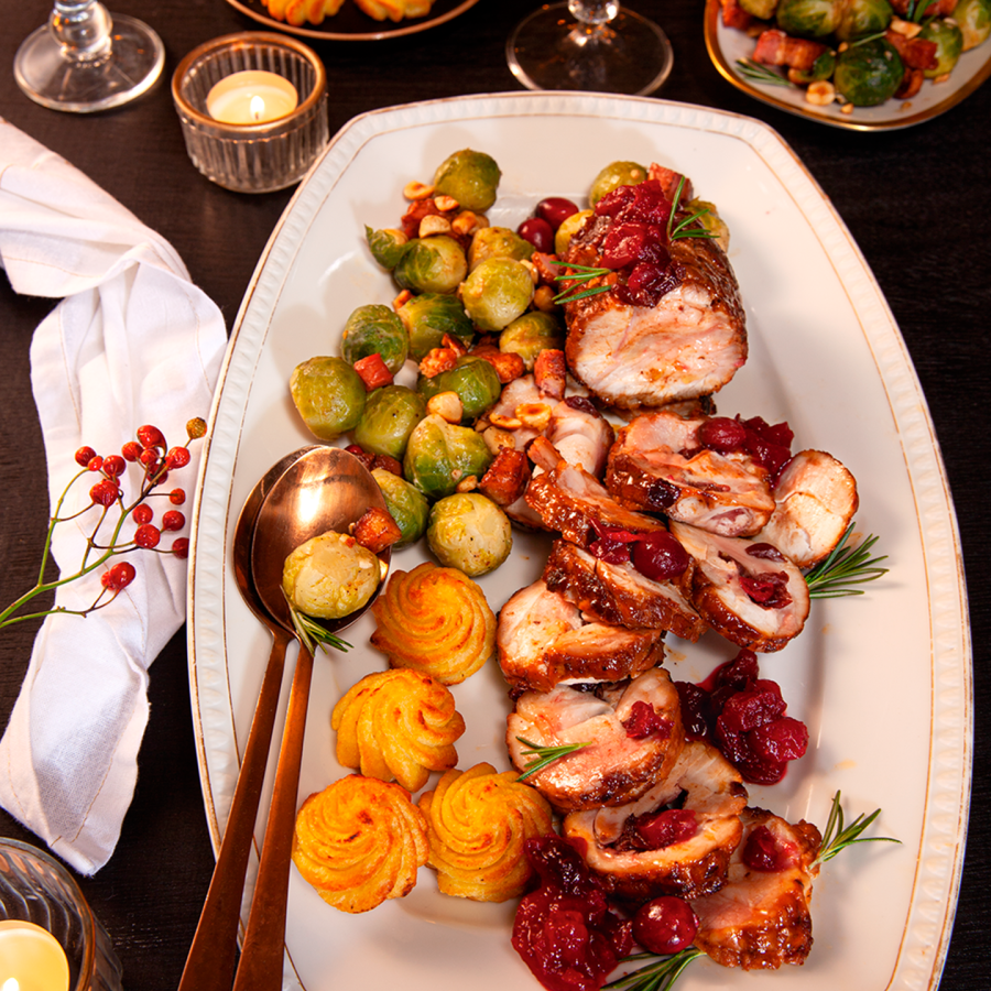 Kiprollade gevuld met cranberries, geserveerd met spruitjes met spek, sinaasappel en hazelnoten