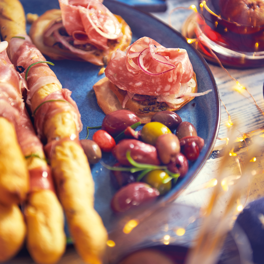 Krokante mini pizzaatjes van filodeeg met olijven crème en Salchichon ham