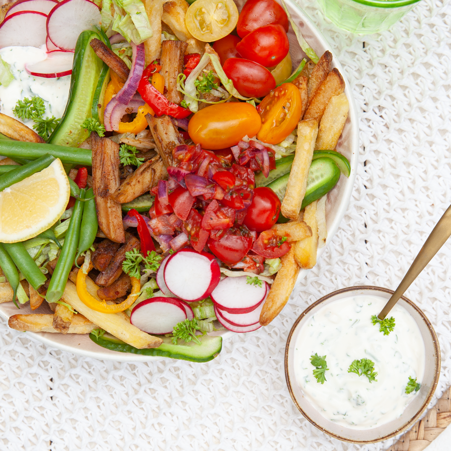 Bowl met ovenfrietjes ,vega shoarma met groente en huisgemaakte  knoflooksaus en tomatensalsa