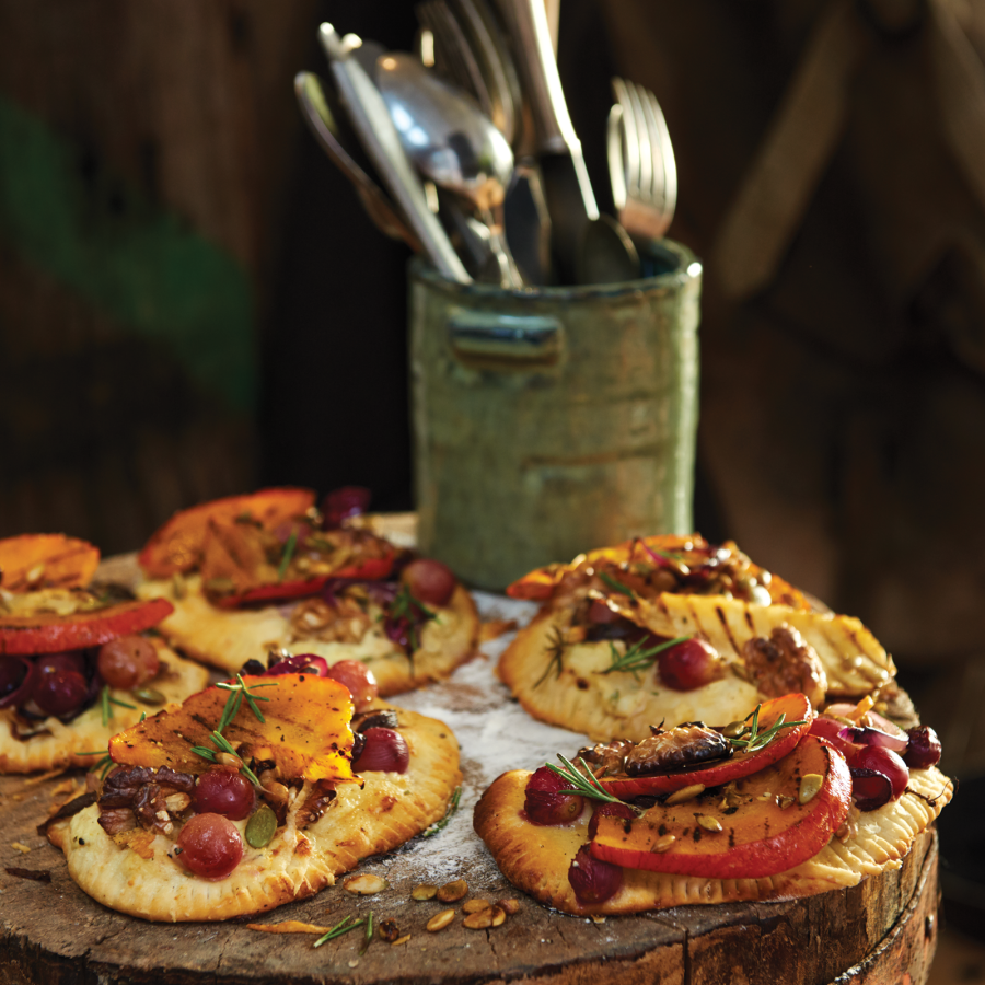 Kleine herfstpizzaatjes met gegrilde pompoen rode ui en druiven