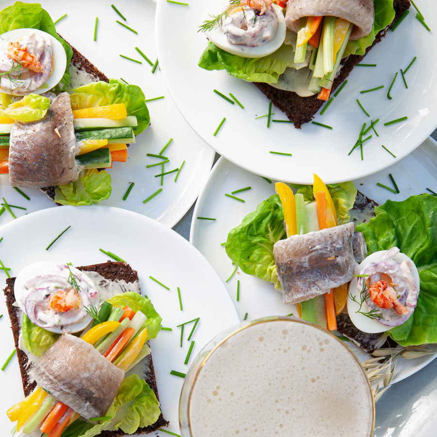Gemarineerde haring rolletjes met zalm en ei op roggebrood